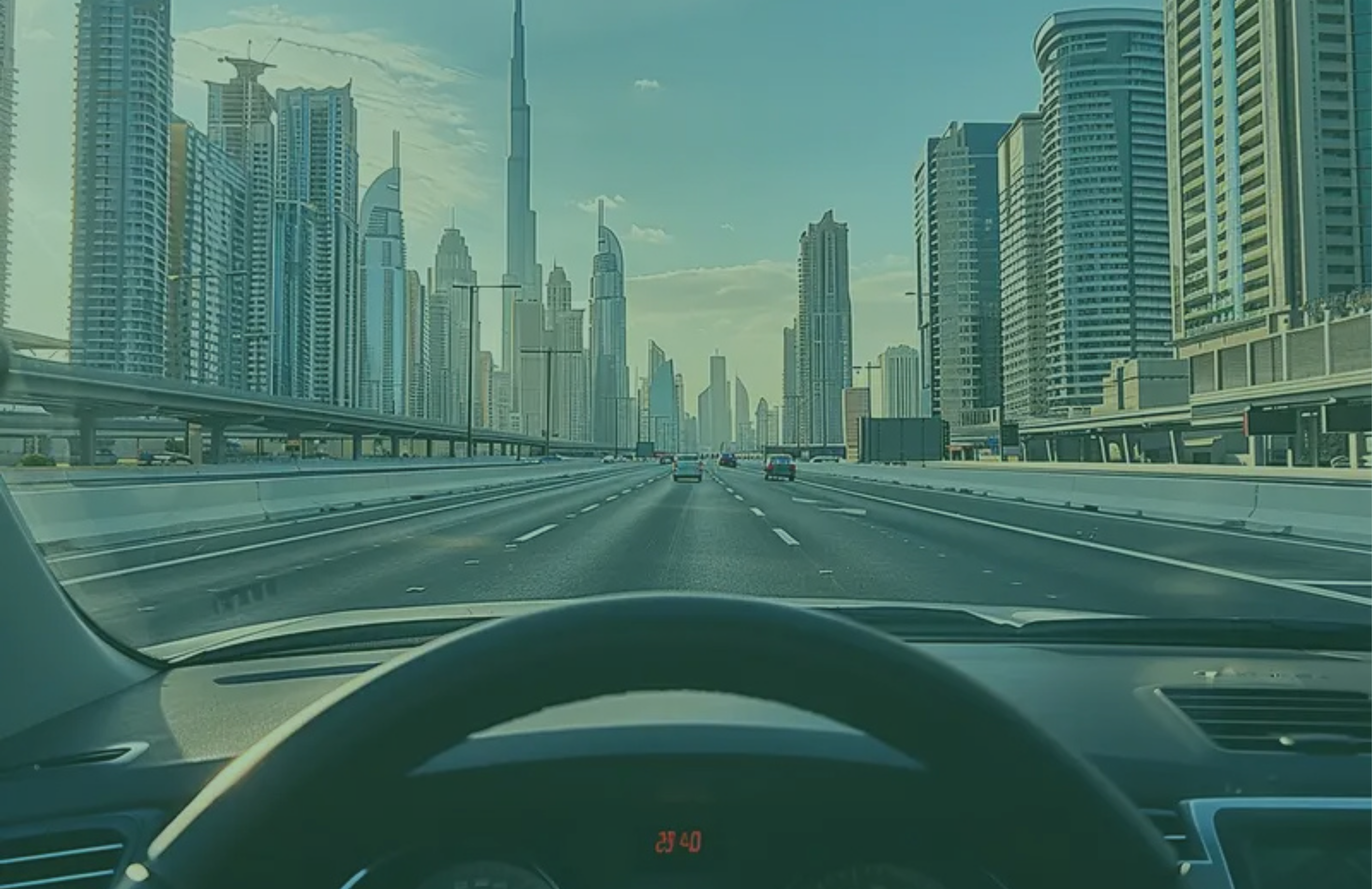 Highway with Dubai skyline in the background, viewed from inside a vehicle.