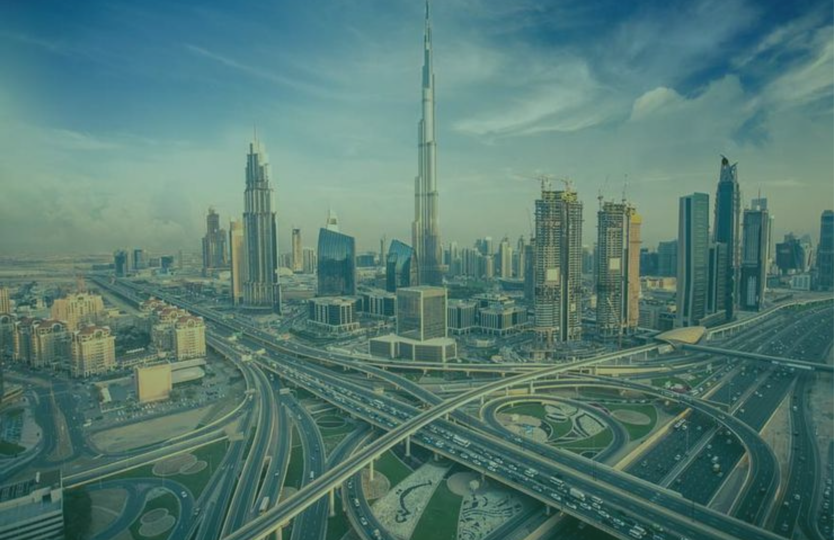 Aerial view of a junction in Dubai with modern skyscrapers and a clear sky.